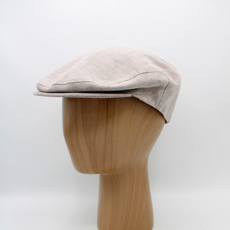 Beige flat cap on a wooden mannequin head against a white background