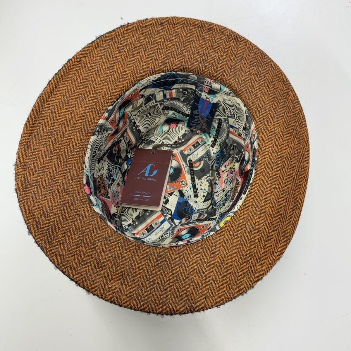 Interior of Potenza fedora 35713 showing orange herringbone underbrim and music-themed printed lining