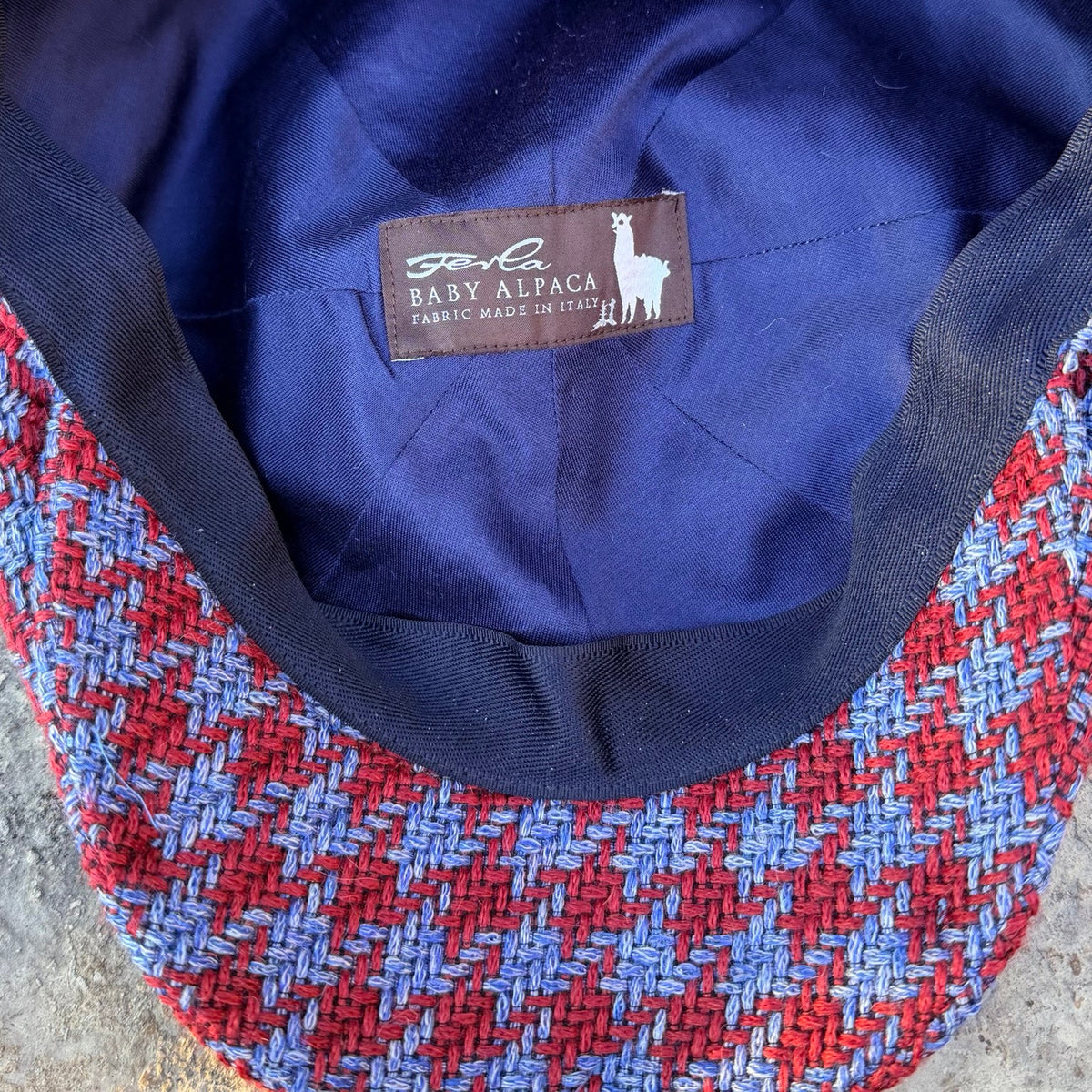Inside The Troubadour newsboy cap, showing navy lining and the Ferla Baby Alpaca fabric label.