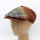 Plaid cap on a wooden mannequin head against a white background