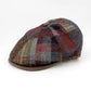 A classic flat cap made of a multicolor plaid tweed fabric with a brown leather visor, photographed on a clean white background.