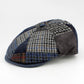 A patchwork flat cap made of multiple textured fabrics including houndstooth, corduroy, and tweed in shades of navy, gray, brown, and black, photographed on a seamless white background.
