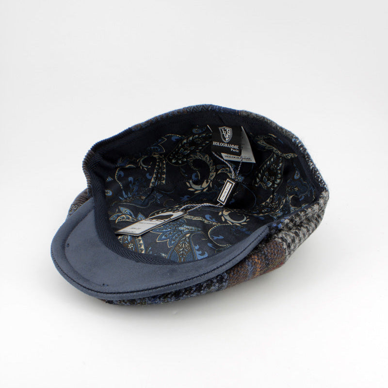 A navy blue flat cap with a patterned lining, shown from the underside on a clean white background.