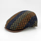 A classic flat cap in a textured houndstooth pattern of navy blue, brown, and beige, with a solid brown faux leather visor, photographed on a clean white background.