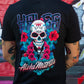 A person wearing a black t-shirt, viewed from the back, featuring a large colorful graphic of a sugar skull surrounded by red flowers and teal leaves, with 'HOLLY' above and 'Aloha Mierros' below.