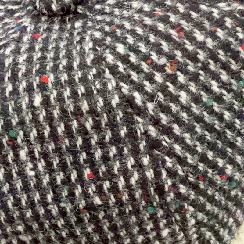 Close-up of black and white virgin wool weave with colorful flecks on cap 52263