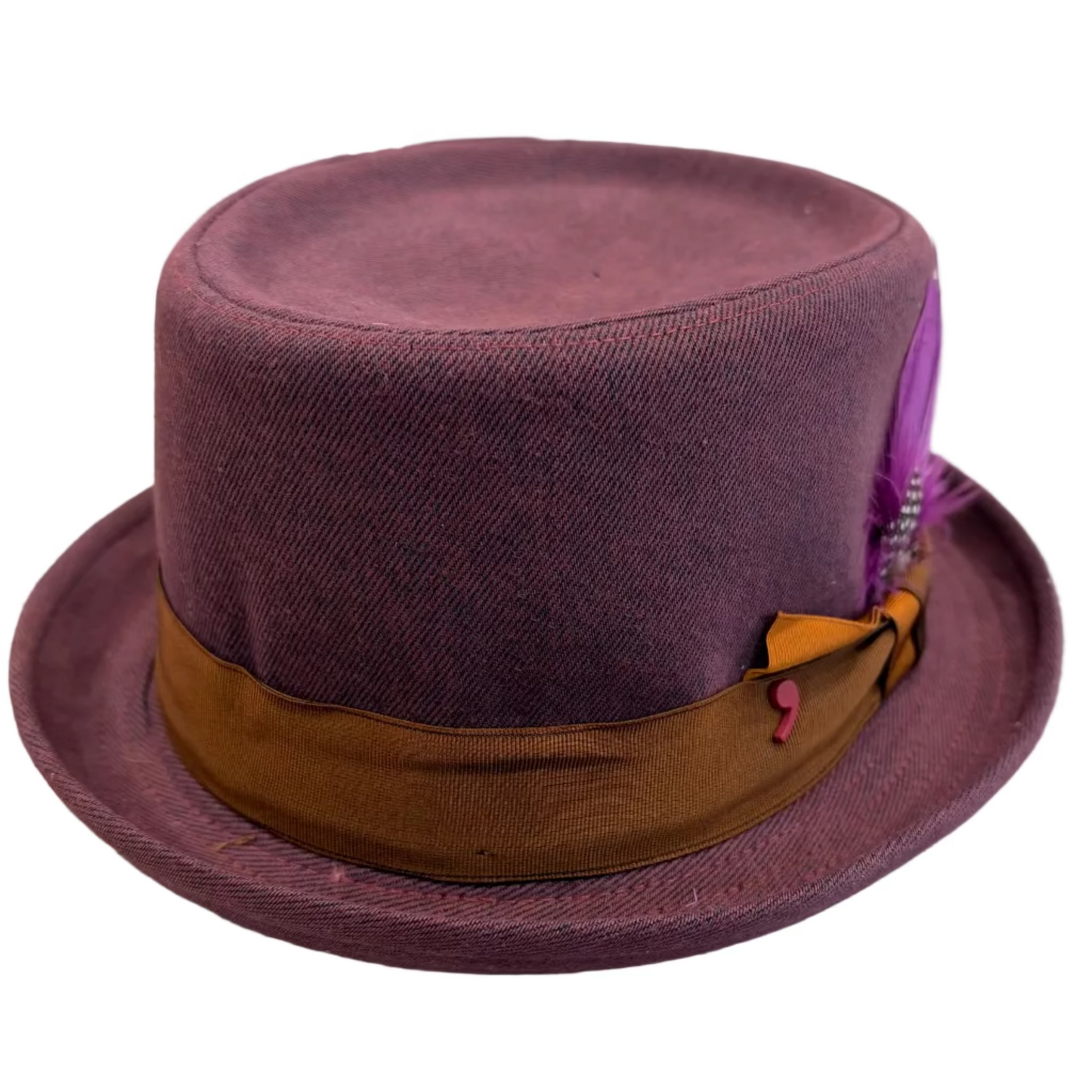 A small top hat in a textured plum purple fabric, featuring a wide brown satin band and a purple feather accent, resting on a White background.