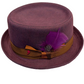 A purple denim pork pie hat with a brown ribbon band, a purple feather, and a decorative brooch, resting on white background.