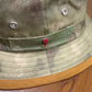 British camo bucket hat detail showing metal eyelets and red Alfonso emblem