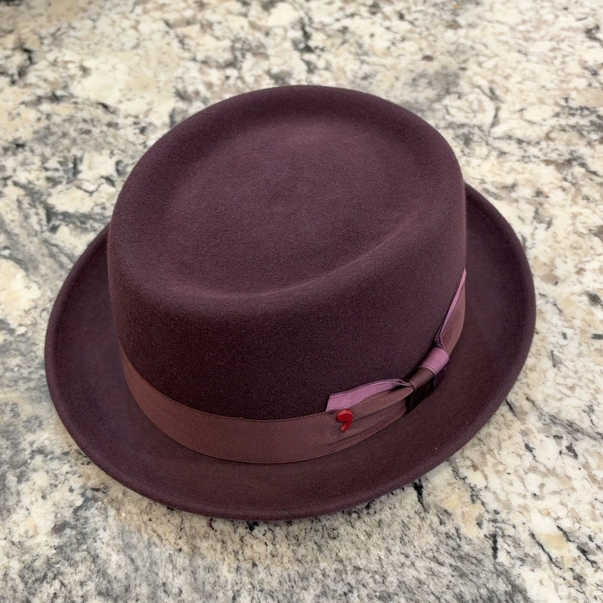 Burgundy Alfonso D’Este pork pie hat with tonal ribbon and mauve bow accent