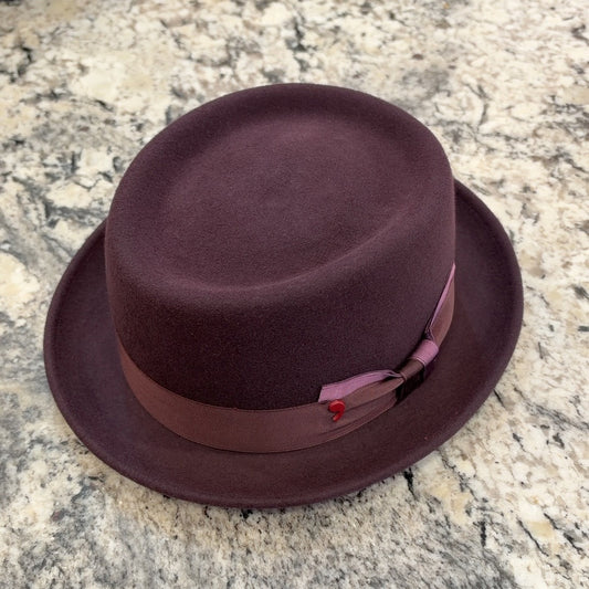 Burgundy Alfonso D’Este pork pie hat with tonal ribbon and mauve bow accent