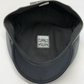 Black cap with a visible brand logo on a white background