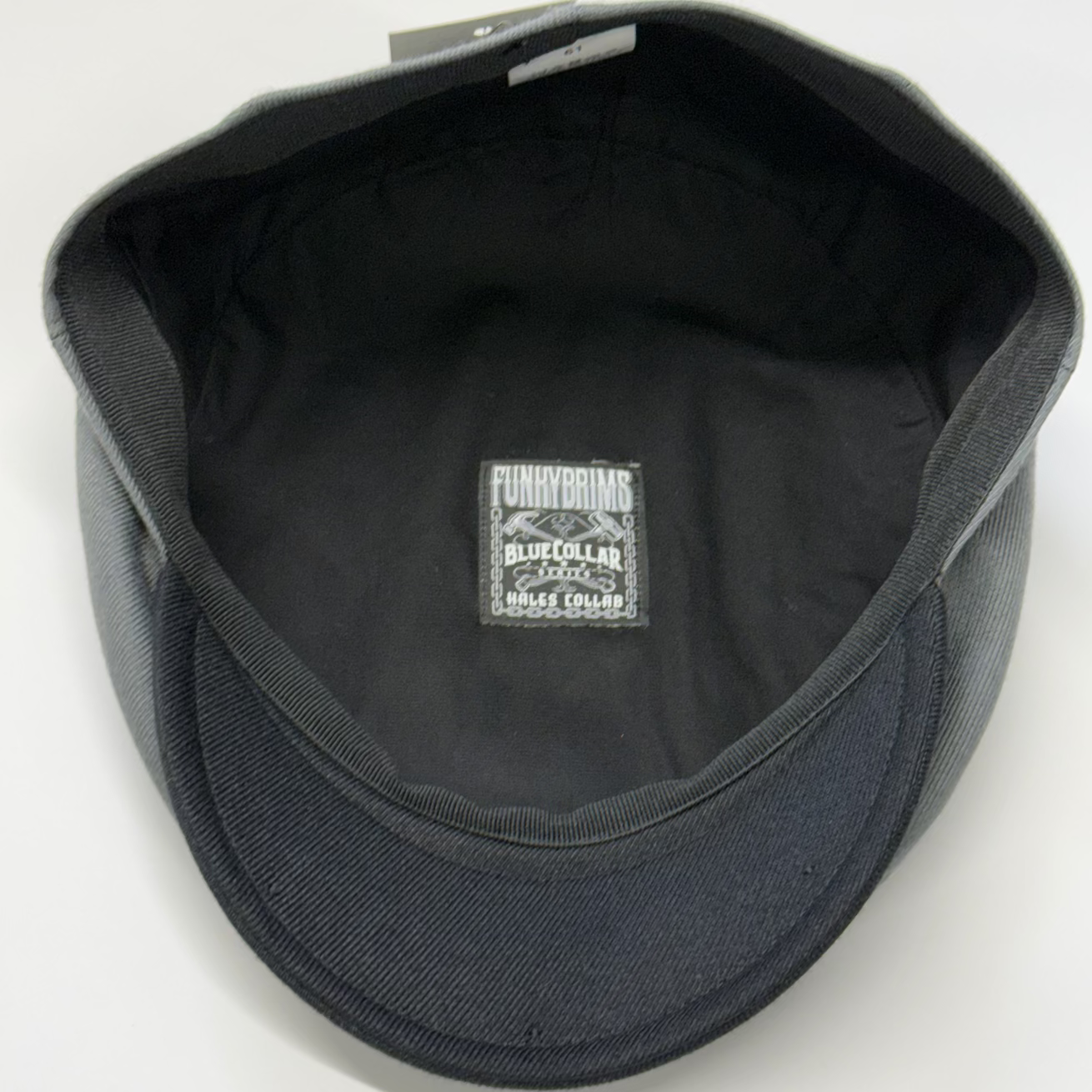 Black cap with a visible brand logo on a white background