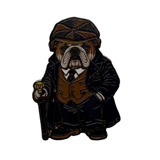 A small enamel pin shaped like a bulldog dressed in vintage clothing, wearing a flat cap, dark coat, brown vest, and holding a cane, photographed on a plain off-white background.