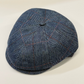 Blue checkered flat cap on a light beige background