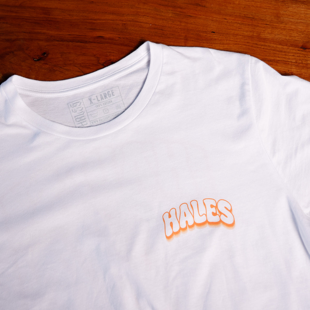 White tee shirt with "Hales" in orange letters on the front.