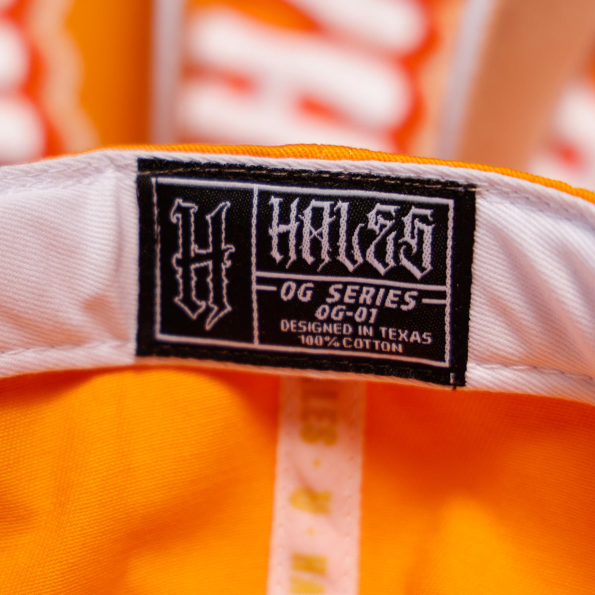 Close-up of a vintage orange and white Hales OG Series cap interior label, showing the brand name 'HALES' and model details.