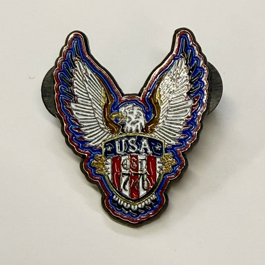 Eagle-shaped pin with 'USA' and year '1776' on a white background