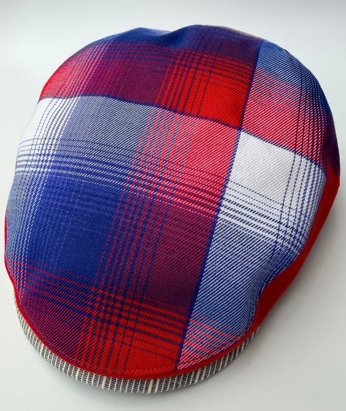 Plaid-patterned headband with red, blue, and white colors on a light gray background