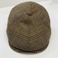 A classic flat cap in a brown and beige houndstooth pattern with subtle orange-brown stripes, photographed on a clean white background.