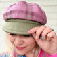 Woman wearing a colorful shirt and two hats with a blurred background