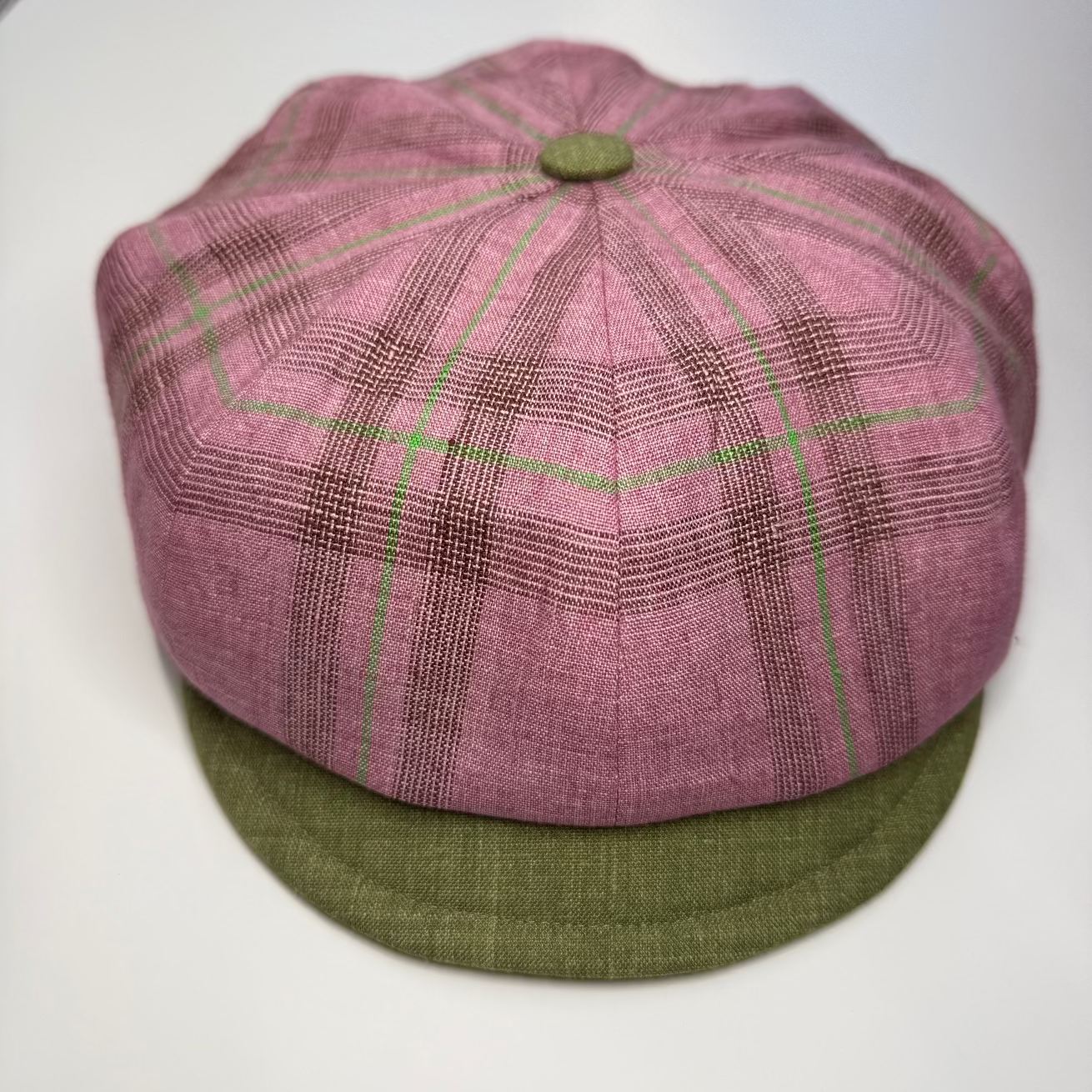Pink and green checkered cap on a white background