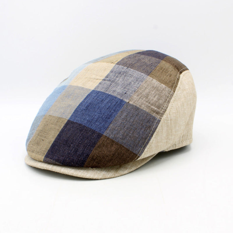 A structured flat cap with a plaid pattern in beige, blue, brown, and navy, shown on a plain white background.