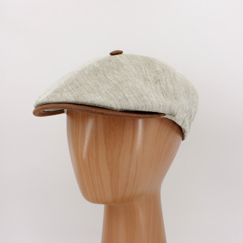 The LinenShelby – Sage by FunkyBrims, a light green linen-style flat cap with warm brown accents and a classic Shelby-inspired silhouette.