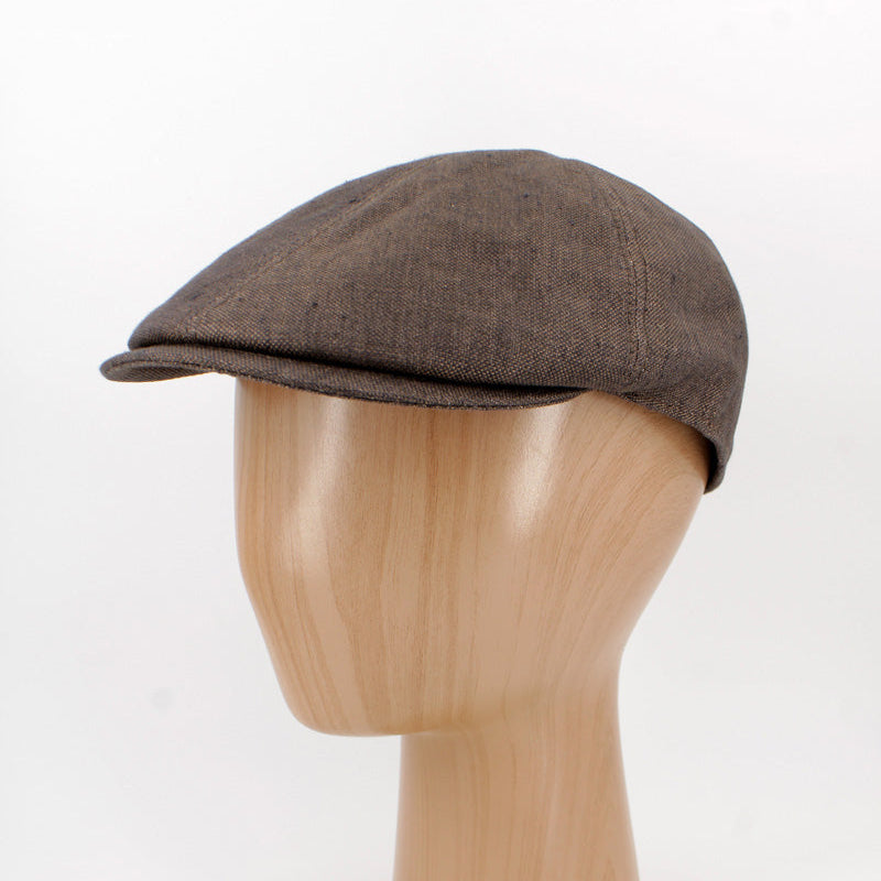 A dark brown flat cap displayed on a light wood mannequin head against a plain white background.