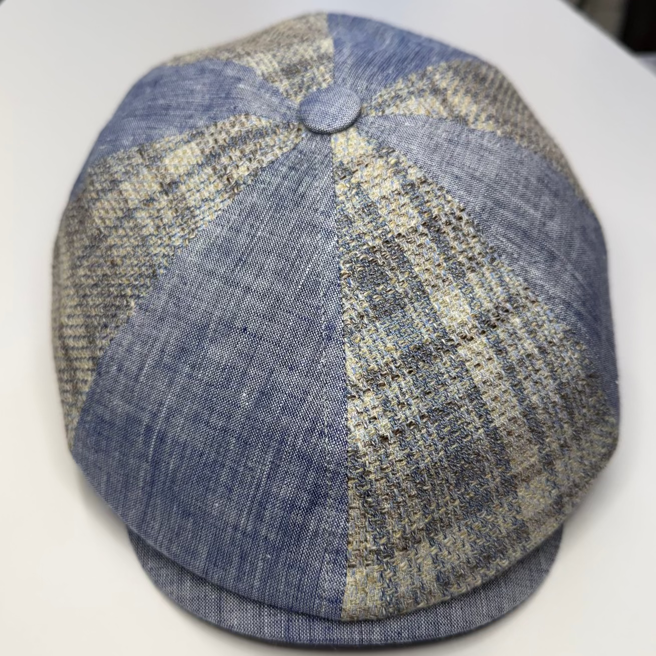 Blue and beige checkered cap on a white surface