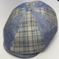 Blue checkered flat cap on a white surface