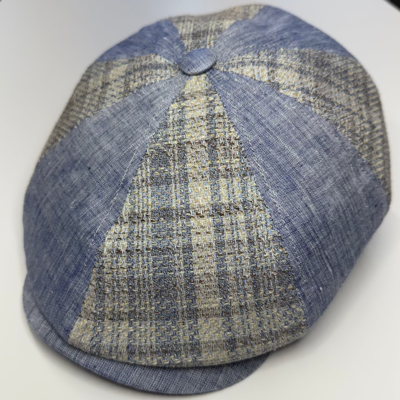 Blue checkered flat cap on a white surface