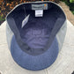 A close-up of a cap's interior showing a blue herringbone patterned visor, a dark gray ribbed band, a gray and white gingham patterned side panel, and a visible 'FUNKY BRIMS' brand label.