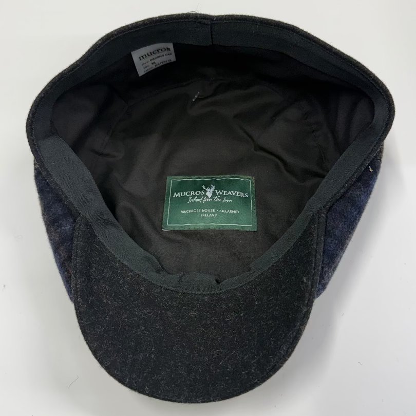 Dark gray flat cap with green label on a white background