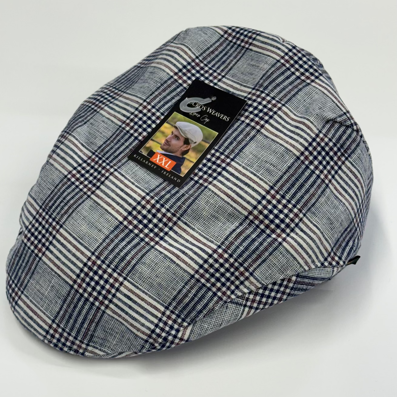 Plaid-patterned flat cap with a brand label on a white background