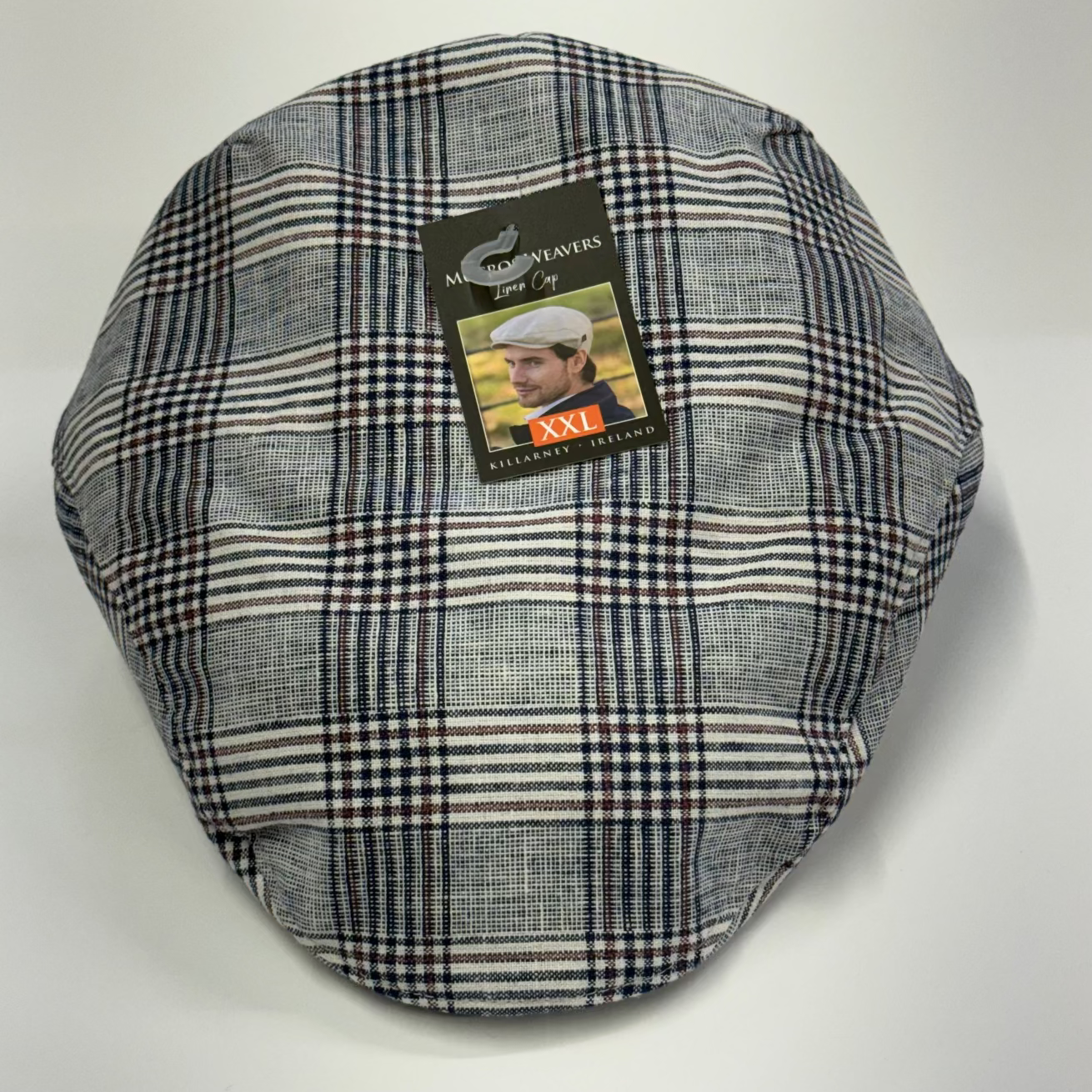Plaid flat cap with a brand label on a white background