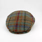 A classic flat cap made of textured tweed fabric in a brown, green, and red plaid pattern, photographed on a clean white background.