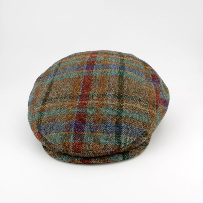 A classic flat cap made of textured tweed fabric in a brown, green, and red plaid pattern, photographed on a clean white background.