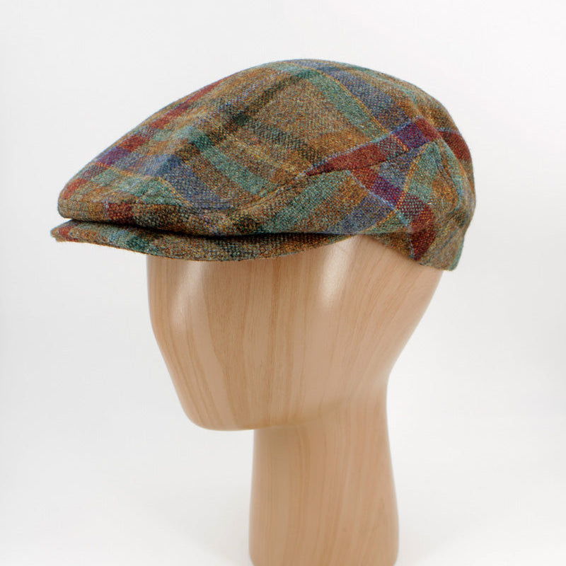 A multicolor plaid flat cap displayed on a light wood mannequin head against a white background.