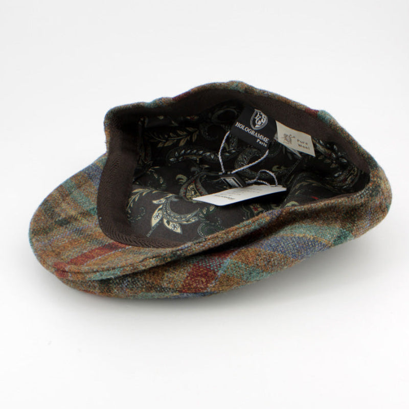 A vintage tweed flat cap with a multicolor plaid pattern on the exterior and a dark floral patterned lining, shown on a white background with its tags visible.