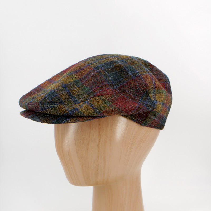 A multicolor plaid tweed flat cap displayed on a light wood mannequin head against a white studio background.