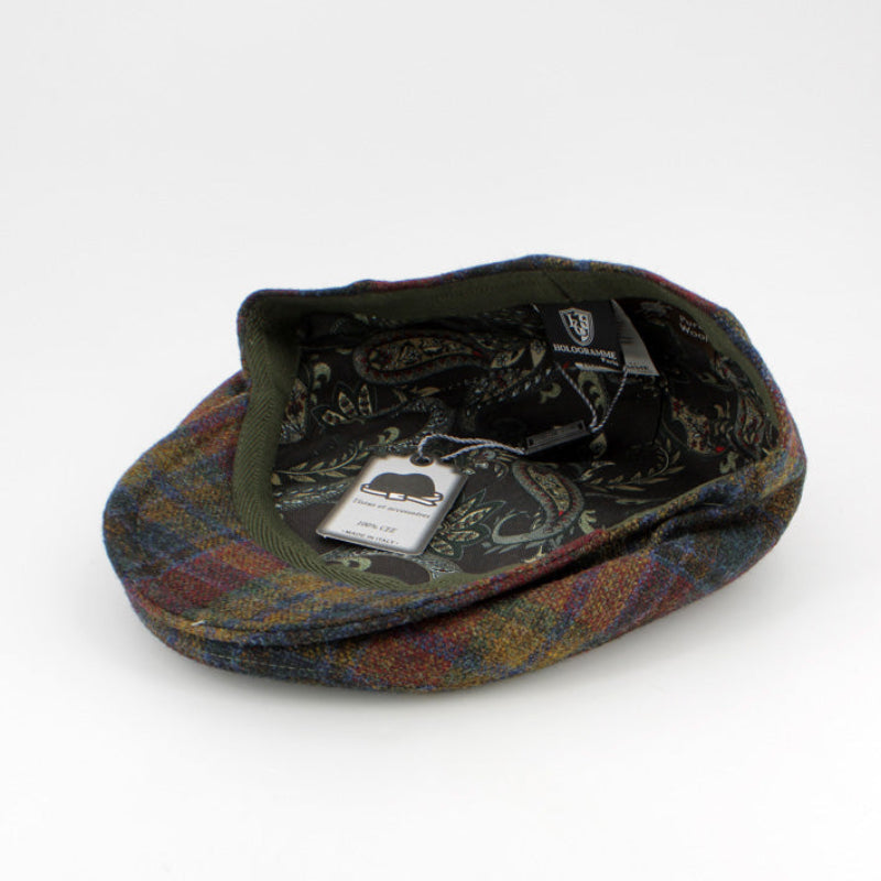 A vintage flat cap in a multicolor tartan pattern with a dark green velvet-like band, shown on a white background with its original paper tag attached.