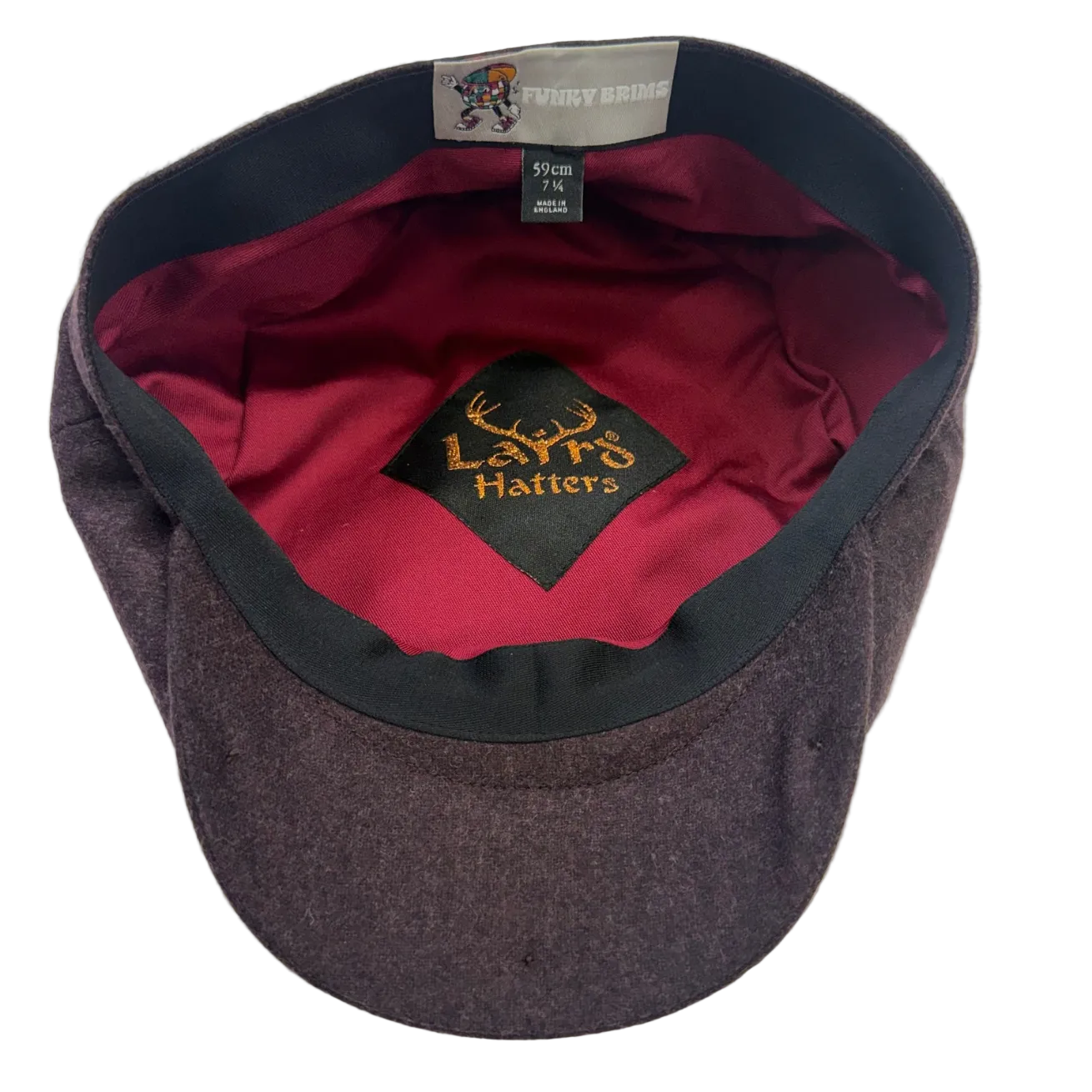 A dark gray wool cap shown from the inside, featuring a burgundy satin lining, a black interior patch with gold embroidered 'Laird Hatters' branding, and a gray interior label.