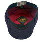 A dark purple and black patterned flat cap with a red interior lining. The inside features a black embroidered patch with yellow text reading 'Laird Hatters' and a gray brand tag at the top edge.