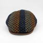 A flat cap made of a textured tweed fabric with vertical stripes of navy blue, brown, and olive green, featuring a solid brown visor, photographed on a light gray background.