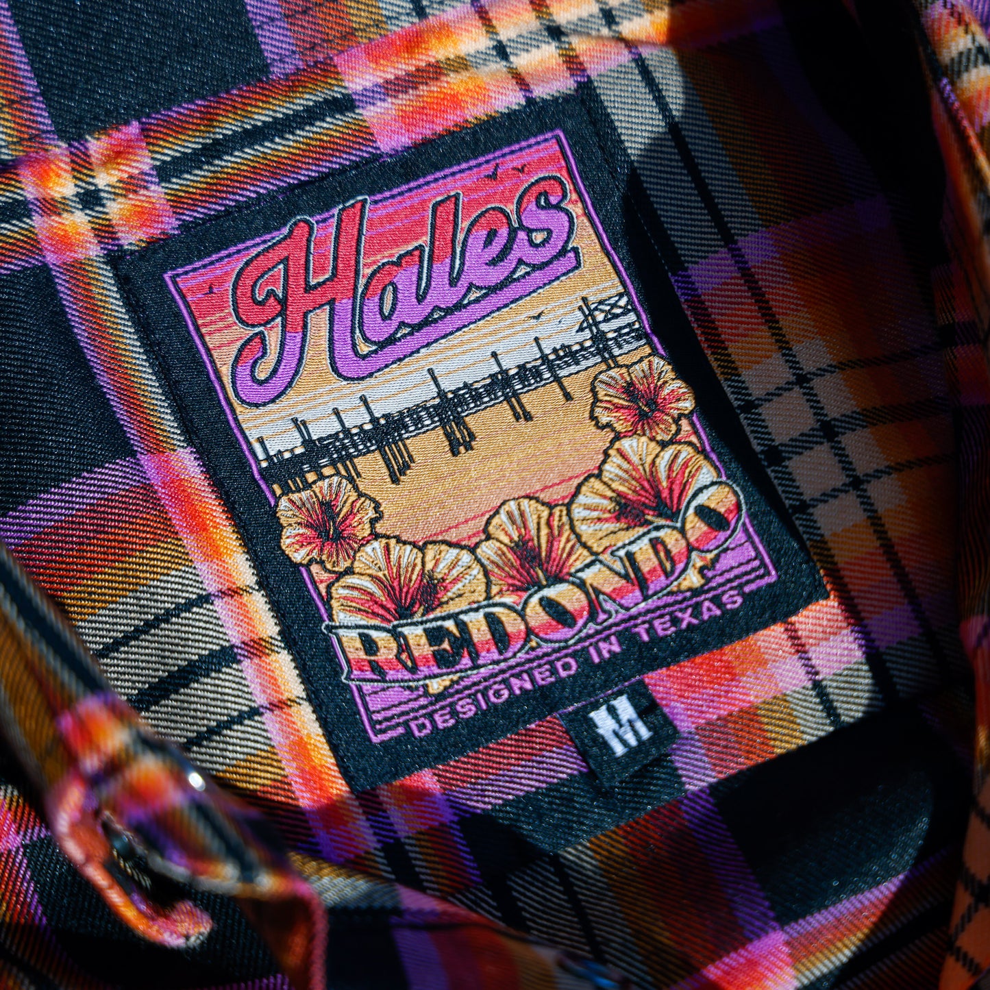 The fabric tag inside the women's Redondo flannel with orange flowers and a beach scene.