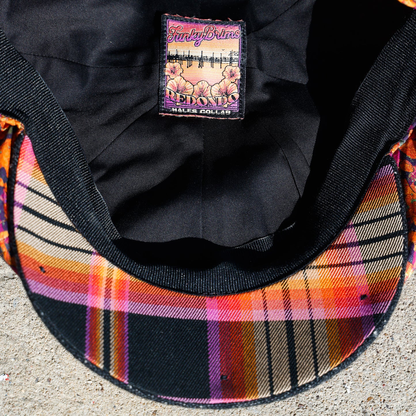 Underside of Newsboy cap with flannel underbrim in orange and black.