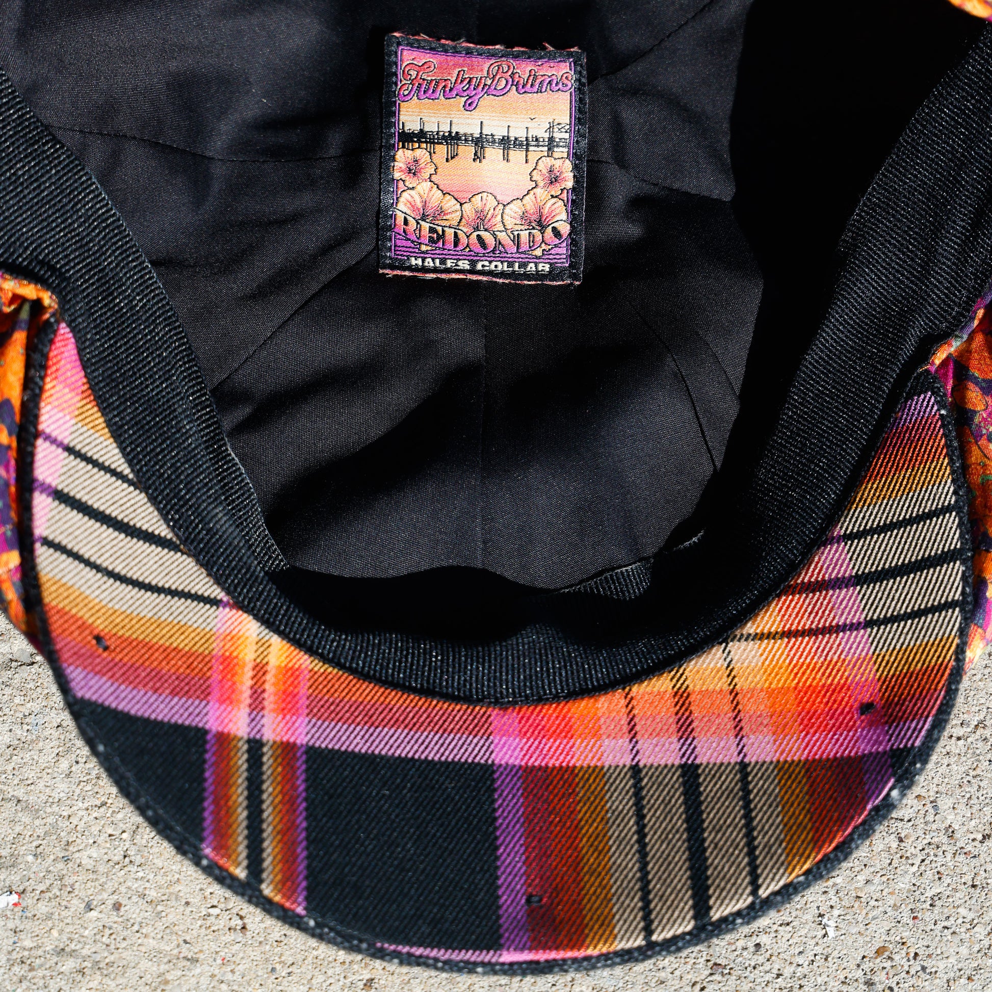 Underside of Newsboy cap with flannel underbrim in orange and black.