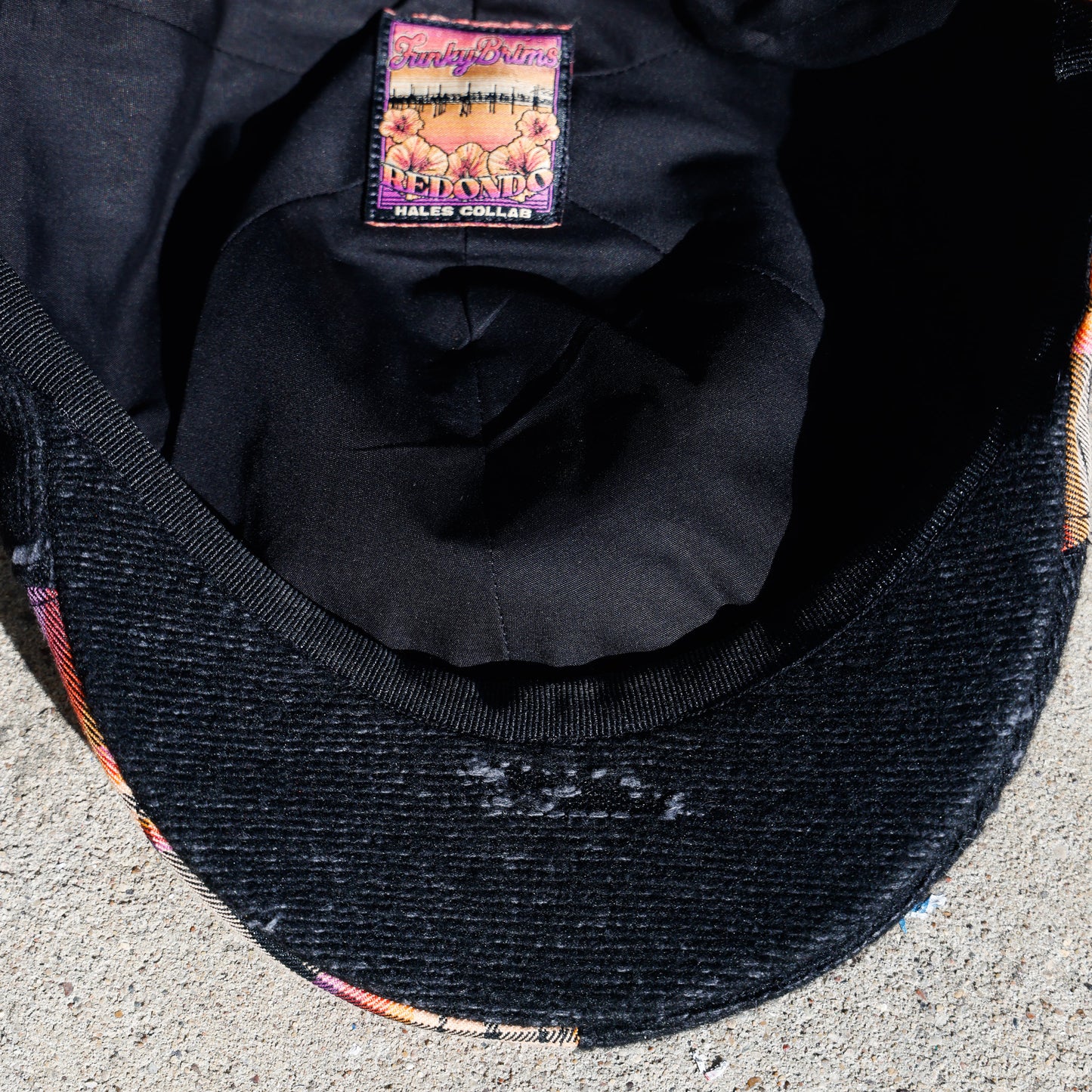 Close-up of the inside of a black woven cap, showing the inner crown lining and a sewn-in brand label that reads 'FunkyBrims' and 'Hales Collab"