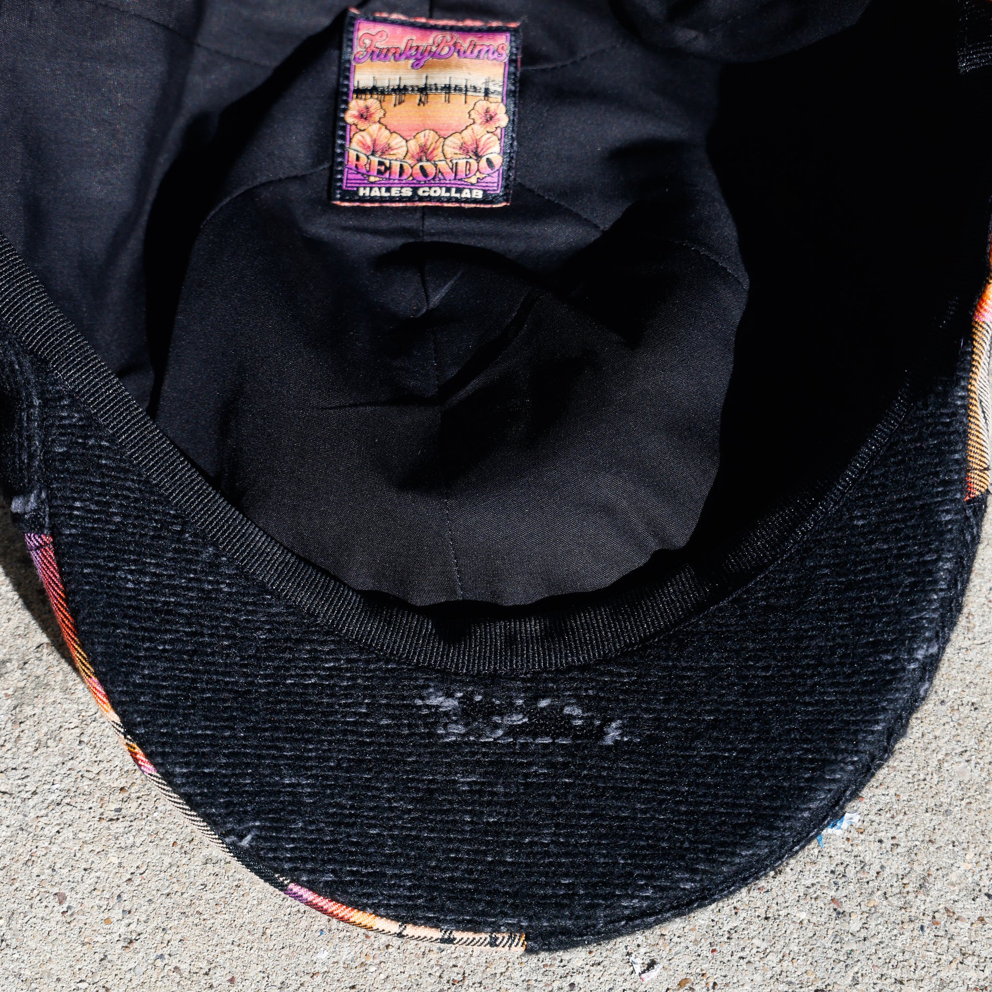 Close-up of the inside of a black woven cap, showing the inner crown lining and a sewn-in brand label that reads 'FunkyBrims' and 'Hales Collab"